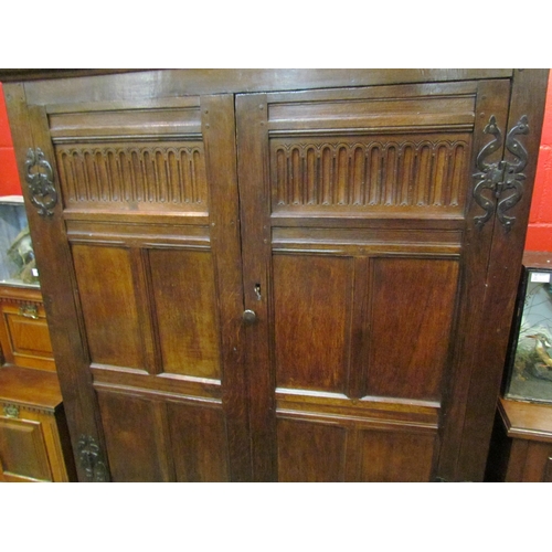 4131 - A 17th Century and later oak two door livery cupboard with carved panelled doors and ornate iron 