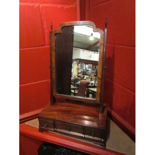 4137 - A 19th Century mahogany toilet mirror, the tilting mirror and brass finials over a three drawer base... 