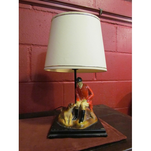 4141 - A vintage plaster table lamp, seated huntsman with his hound, wooden plinth form base