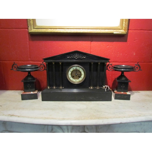 4148 - A slate mantel clock garniture of architectural and urn form, column supports, with key