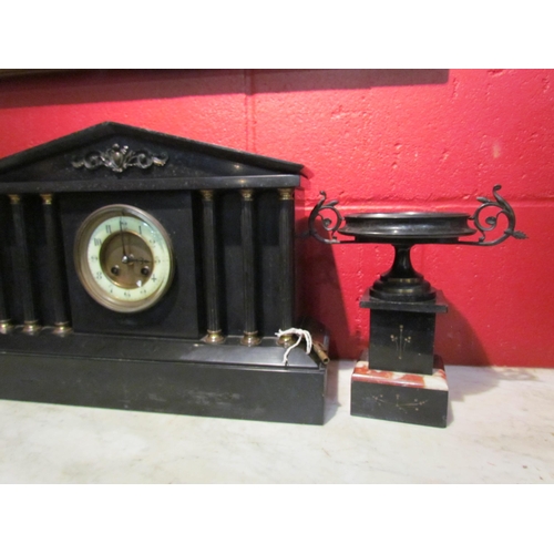 4148 - A slate mantel clock garniture of architectural and urn form, column supports, with key