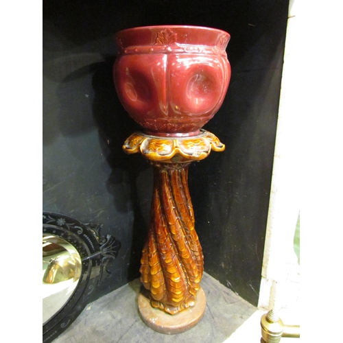 4153 - A Victorian treacle glazed pottery jardiniere stand together with a dark pink glazed jardiniere, 78c... 