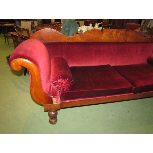 4164 - A Victorian scroll end sofa on turned legs with castors with red velour upholstery and bolster cushi... 