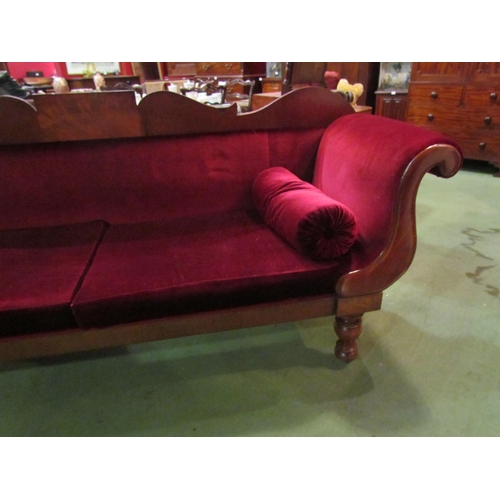 4164 - A Victorian scroll end sofa on turned legs with castors with red velour upholstery and bolster cushi... 