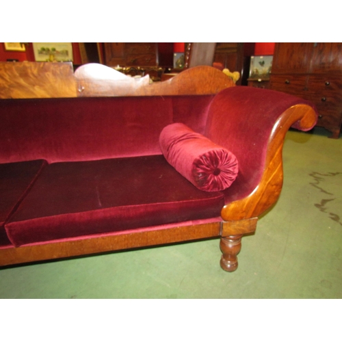 4164 - A Victorian scroll end sofa on turned legs with castors with red velour upholstery and bolster cushi... 