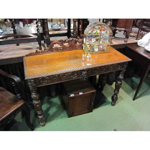 4202 - A carved oak 'Green Man' style side table, 91cm tall x 113cm wide x 43cm deep