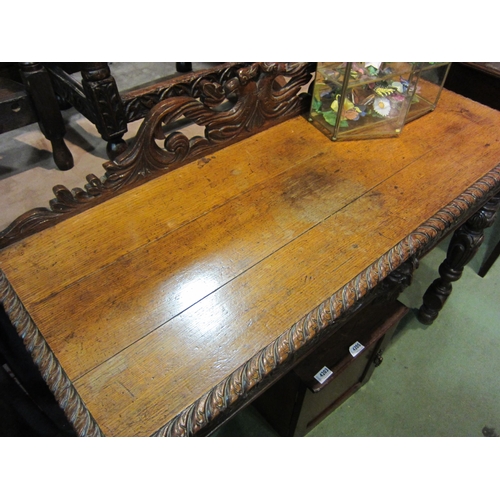 4202 - A carved oak 'Green Man' style side table, 91cm tall x 113cm wide x 43cm deep