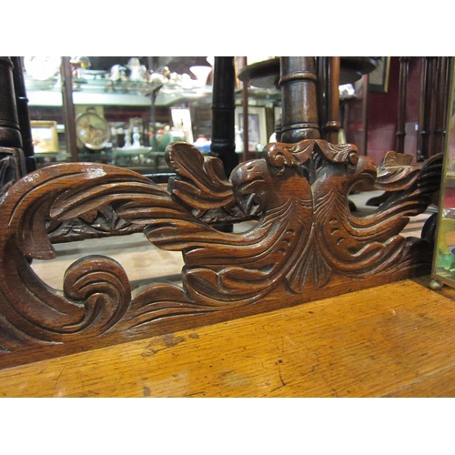 4202 - A carved oak 'Green Man' style side table, 91cm tall x 113cm wide x 43cm deep