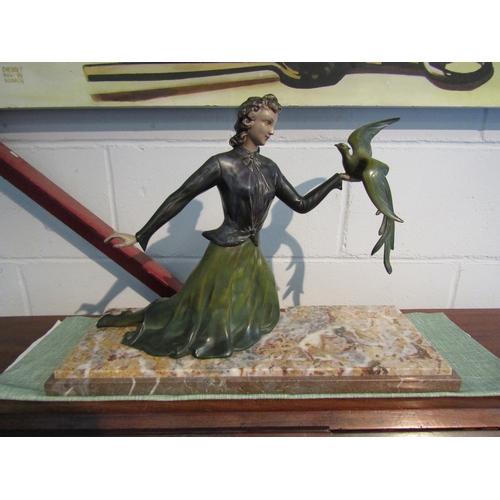 1264 - A painted bronze figure of a lady holding bird on marble base, 33cm tall x 51cm long