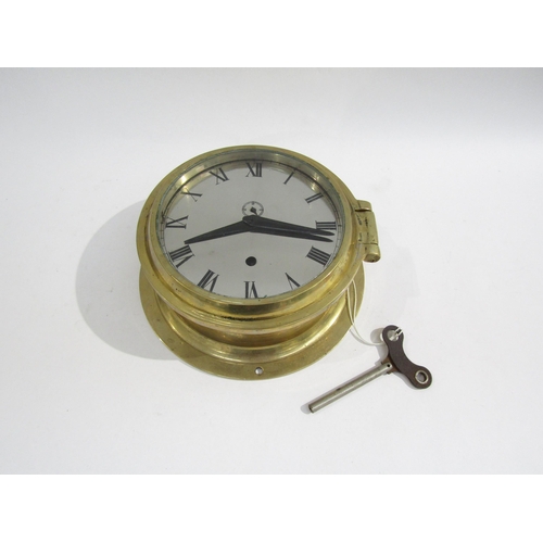 8064 - A brass bulkhead clock with Roman numerals and subsidiary seconds dial, made in Germany, with key. 1... 