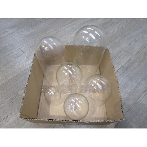 8184 - A group of six varying size glass and plastic domes