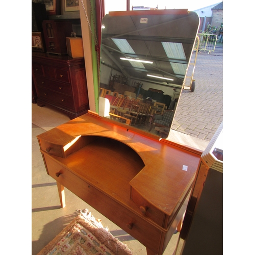 2427 - A 1960's oak dressing chest, the mirror back over alcove flanked by twin drawers, over single long d... 