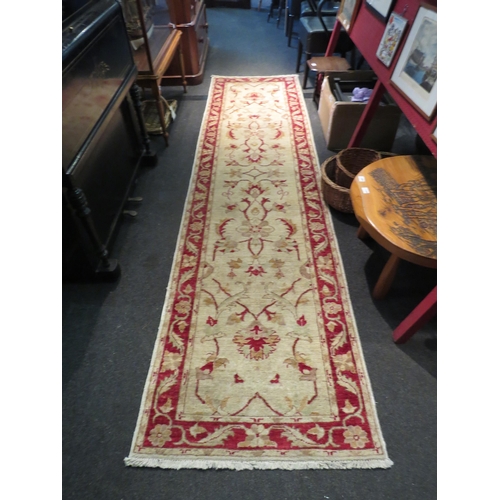 1068 - A runner rug, cream ground with red floral border, 313cm long x 82cm wide