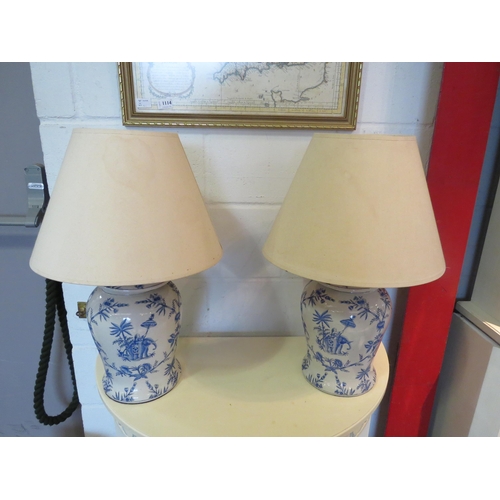 1115 - A pair of blue and white chinoiserie elephant design table lamps with shades