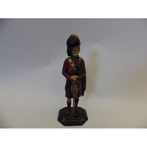 1444 - A vintage cold painted metal figural table lighter in the form of a highlander, 23cm tall