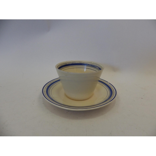 1455 - A Clarice Cliff hand-painted cup and saucer, blue and grey bands, closed wedge handle