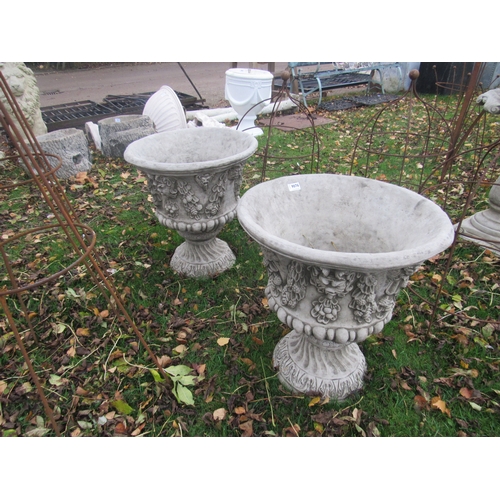 9076 - A pair of decorative composition urns on socles, 23