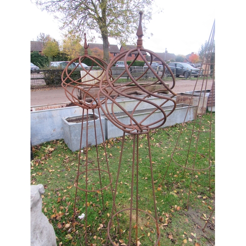 9085 - A pair of steel rust finish decorative orb top obelisks