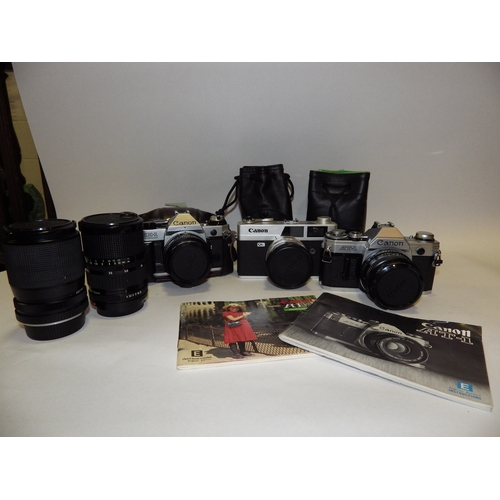5013 - A Canon AE1 Program SLR camera with 50mm lens, a Canon AT-1 SLR camera with 50mm lens and a Canon QL... 
