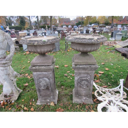 9486 - A pair of reconstituted shallow urns on plinths, 43