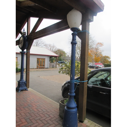 9506 - A blue painted cast alloy set of two lamp posts with shaped plastic shades and matching clock on pos... 