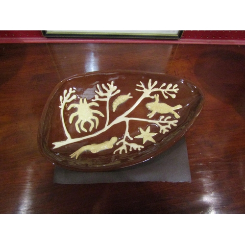 4047 - A glazed terracotta slipware dish with applied sea creatures, signed A. Martin to base, 33cm long