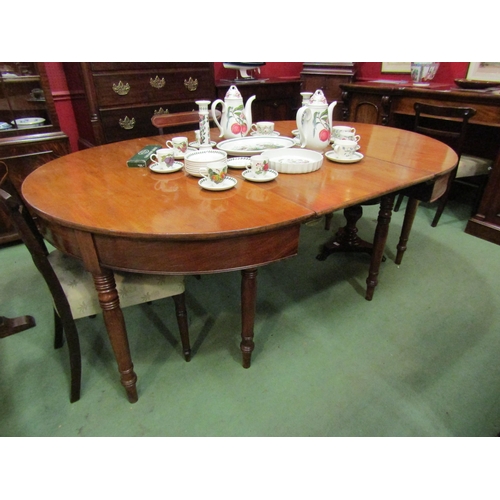 4064 - A 19th Century mahogany D-end dining table with extra leaf and brass connectors on turned and taperi... 