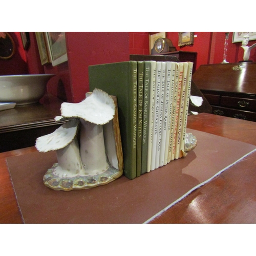 4069 - A pair of handmade pottery book-ends in the form of toadstools together with a selection of Beatrix ... 