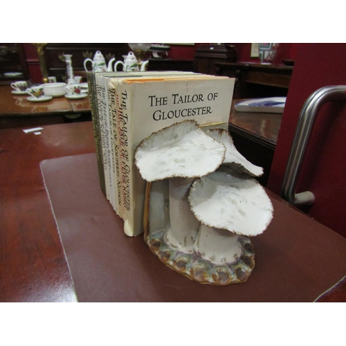 4069 - A pair of handmade pottery book-ends in the form of toadstools together with a selection of Beatrix ... 