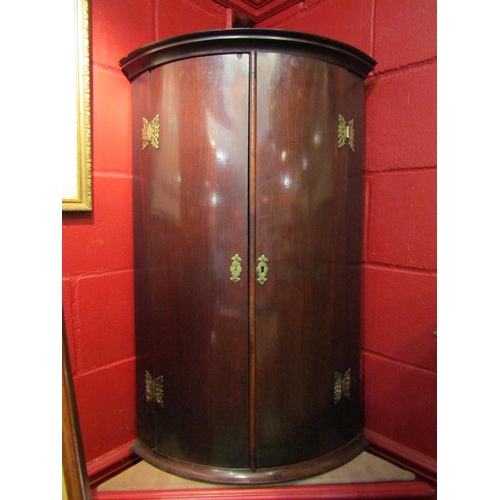 4135 - A 19th Century mahogany bow front corner cupboard with brass hinges, 91cm tall x 59cm wide