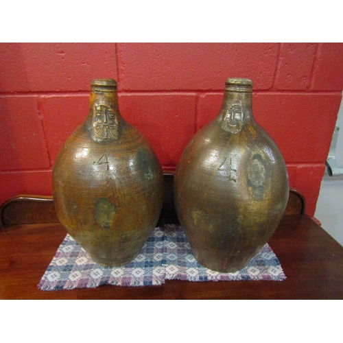 4154 - Two 18th Century large salt glazed stoneware Bellarmine jugs, bulbous form with a tapering neck and ... 