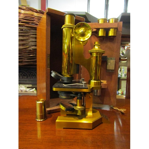 4191 - An R & J. Beck Ltd. brass student microscope in fitted mahogany case with attachments