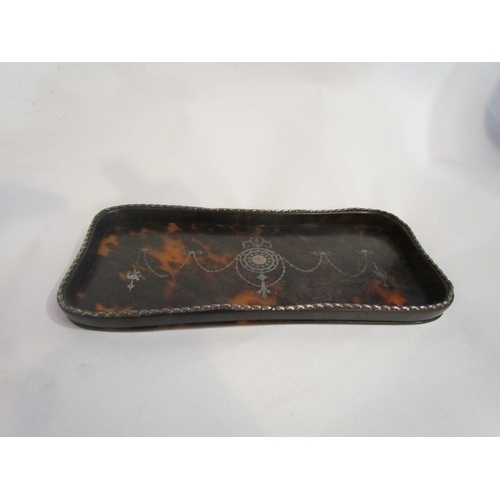 4323 - A Tortoiseshell dressing table tray with silver border and pique decorated centre, 23cm x 11cm