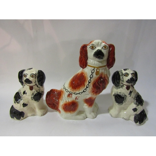 4263 - A pair of Staffordshire style black and white spaniels together with a larger white and tan example,... 