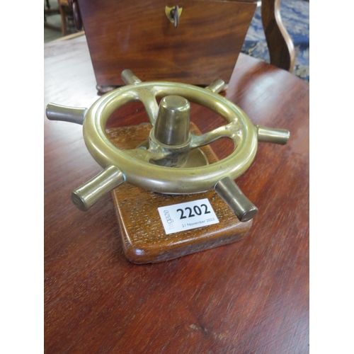 2223 - A bronze ship's steering wheel on oak wall hanging mount              (R)     £25