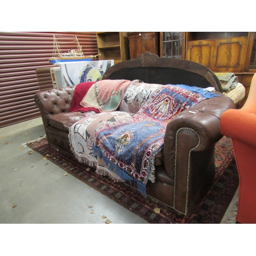 2440 - A brown leather Chesterfield sofa, some tears