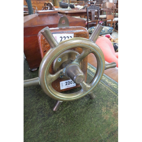 2223 - A bronze ship's steering wheel on oak wall hanging mount              (R)     £25