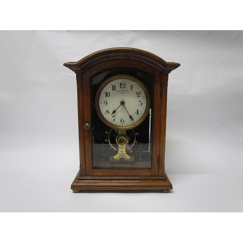 7766 - An early 20th Century oak cased Eureka clock with early electric movement and large balance wheel, A... 