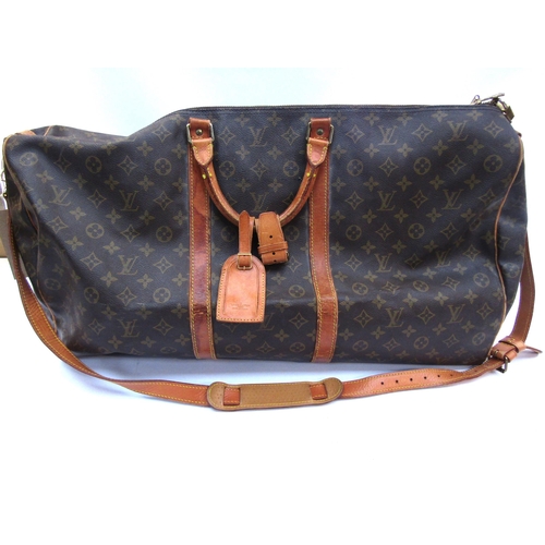 7846 - LOUIS VUITTON; Keepall 60 Boston travel bag. Brown monogram. The leather handles, banding and piping... 