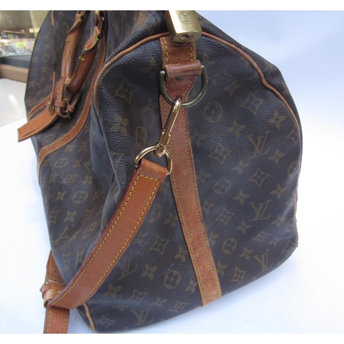 7846 - LOUIS VUITTON; Keepall 60 Boston travel bag. Brown monogram. The leather handles, banding and piping... 