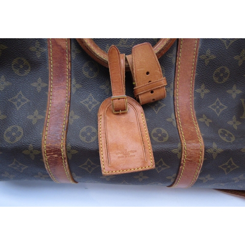 7846 - LOUIS VUITTON; Keepall 60 Boston travel bag. Brown monogram. The leather handles, banding and piping... 