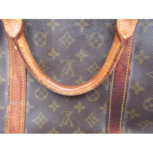 7846 - LOUIS VUITTON; Keepall 60 Boston travel bag. Brown monogram. The leather handles, banding and piping... 