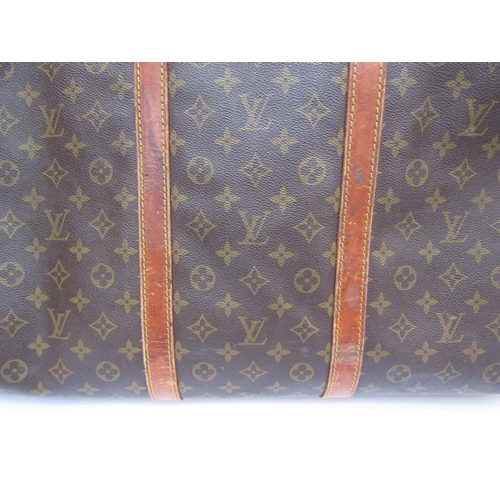 7846 - LOUIS VUITTON; Keepall 60 Boston travel bag. Brown monogram. The leather handles, banding and piping... 