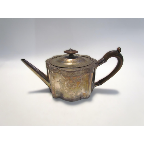 7453 - A George III silver teapot of serpentine form with monogrammed cartouche, floral swag detail, treen ... 