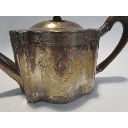 7453 - A George III silver teapot of serpentine form with monogrammed cartouche, floral swag detail, treen ... 