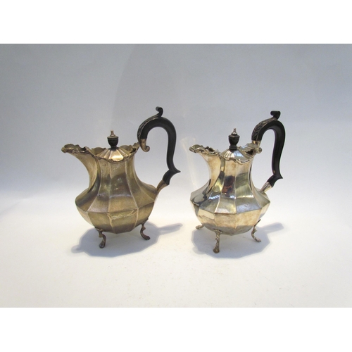 7458 - A pair of silver chocolate pots with ebony handles and knop, raised on four feet with 