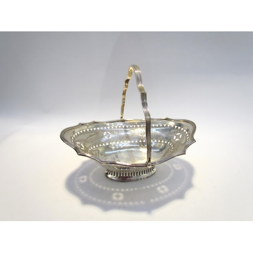 7461 - A Charles Stuart Harris silver basket, swing handle, with pierced borders and engraved swag design, ... 