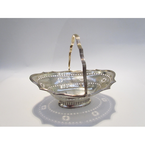 7461 - A Charles Stuart Harris silver basket, swing handle, with pierced borders and engraved swag design, ... 