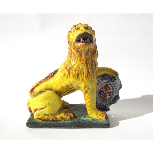 7518 - A 19th Century Italian faience figure of a lion with heraldic crest, 23cm high