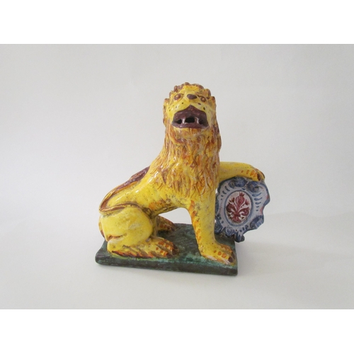 7518 - A 19th Century Italian faience figure of a lion with heraldic crest, 23cm high